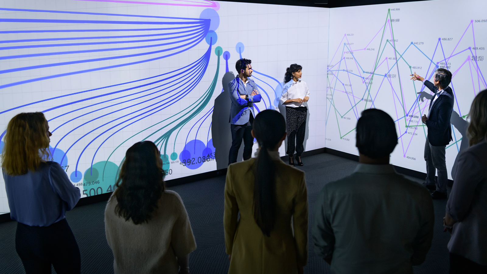 a group of people standing in front of a large screen