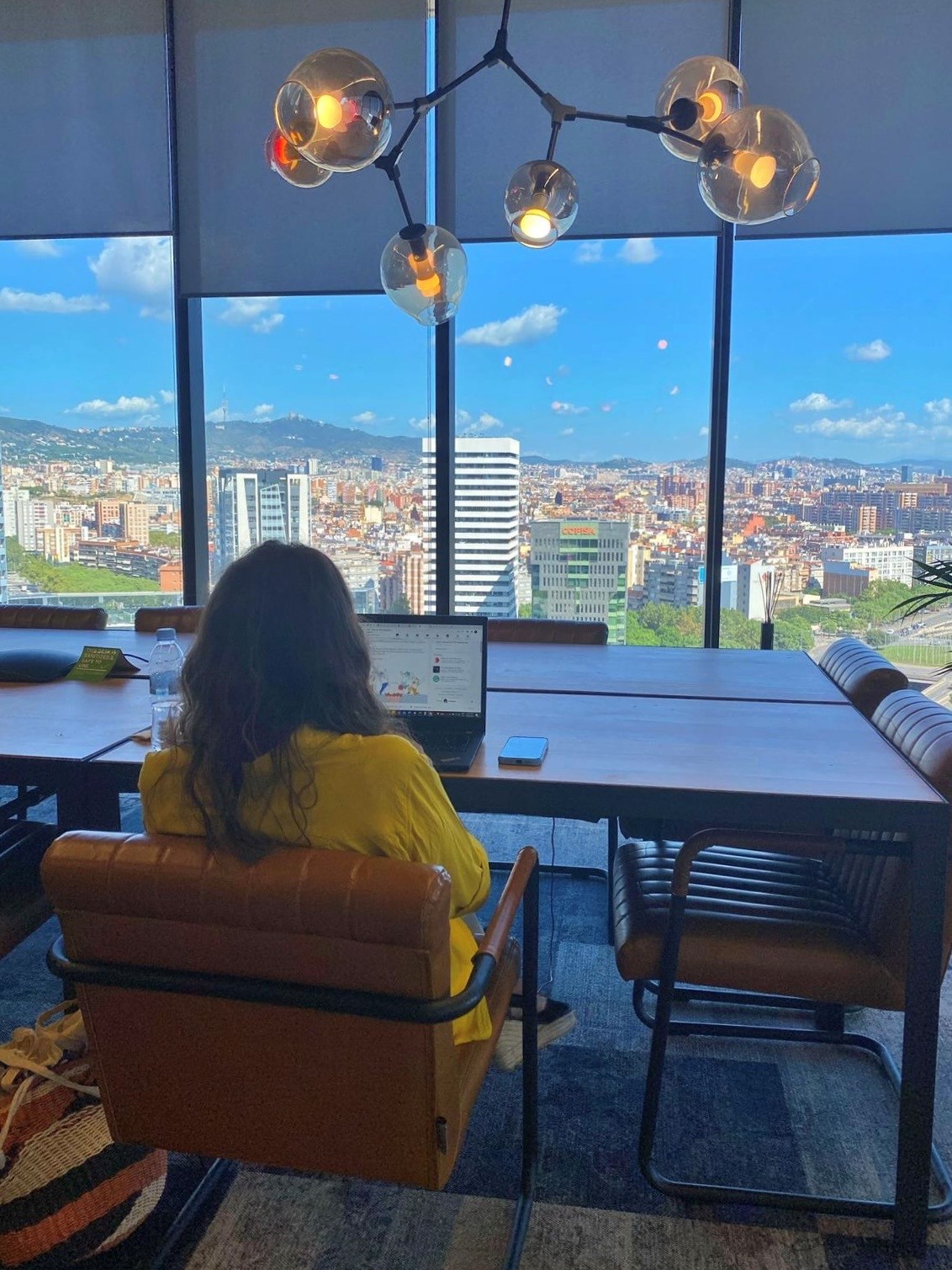 a person sitting at a table looking out a window