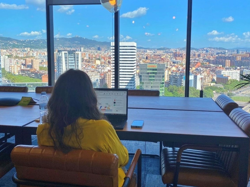 a person sitting at a table looking out a window
