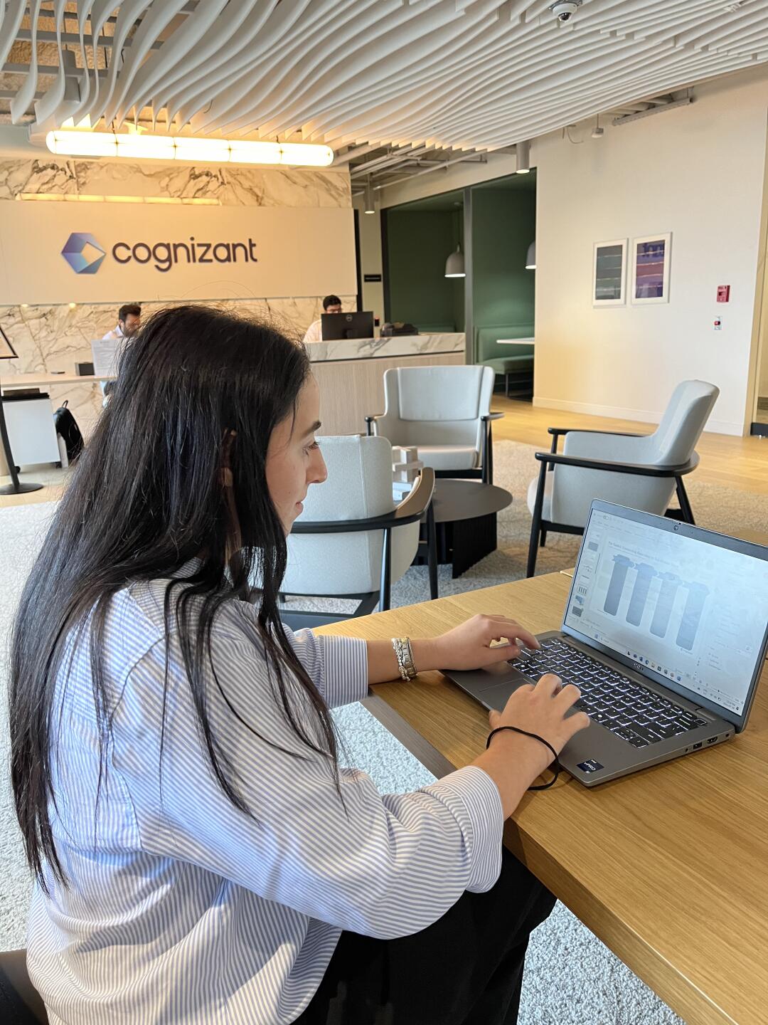 a person sitting at a desk using a laptop