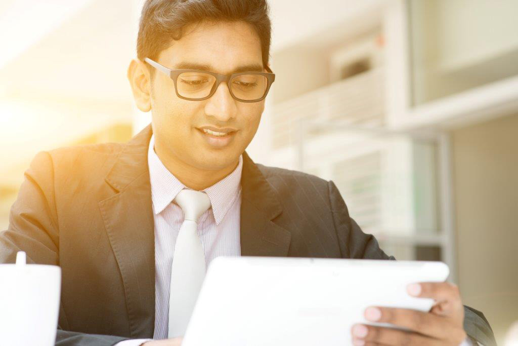a person in a suit and tie looking at a tablet