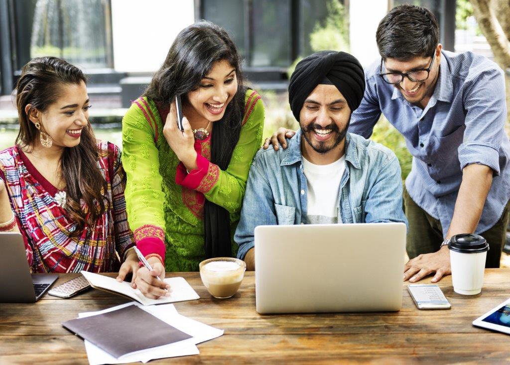 a group of people looking at a laptop