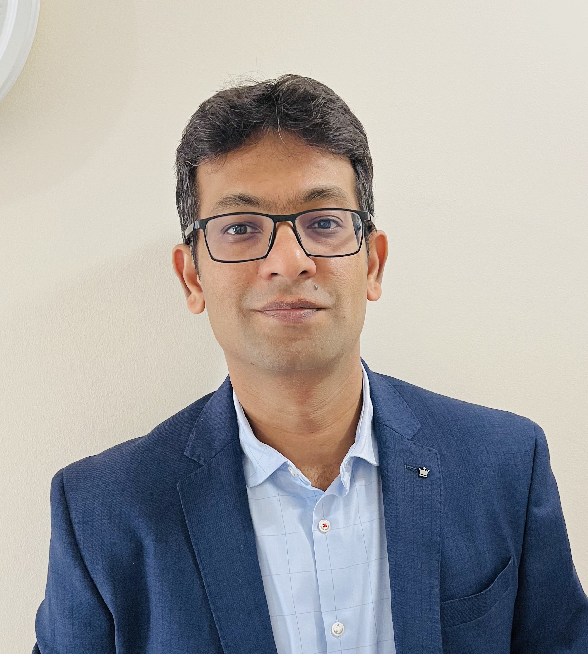 a person wearing glasses and a suit
