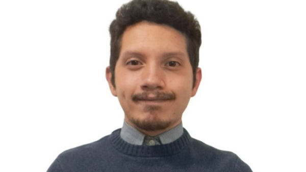 una persona con bigote y un suéter azul