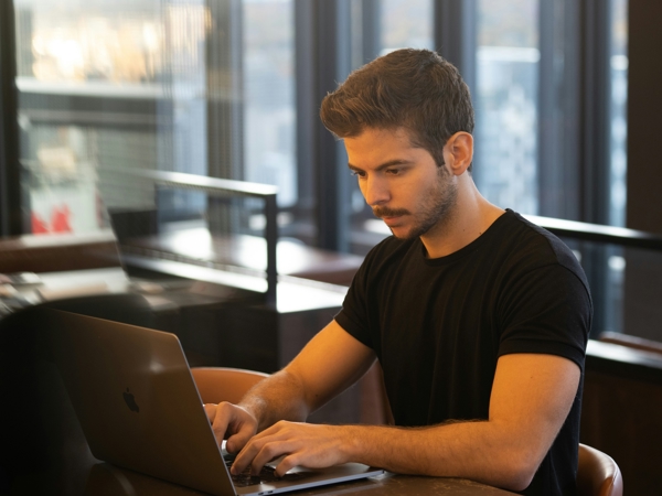 a person sitting at a table using a laptop