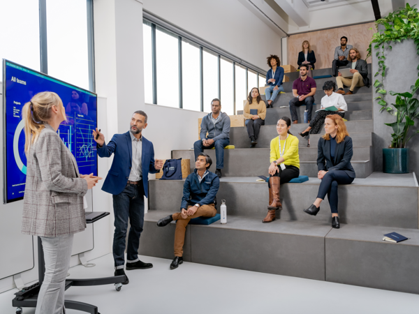 a person standing in front of a person standing in front of a group of people sitting on stairs