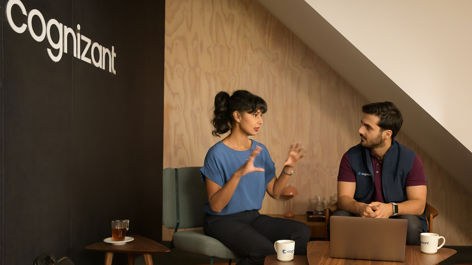 a person and person sitting on a chair with a laptop