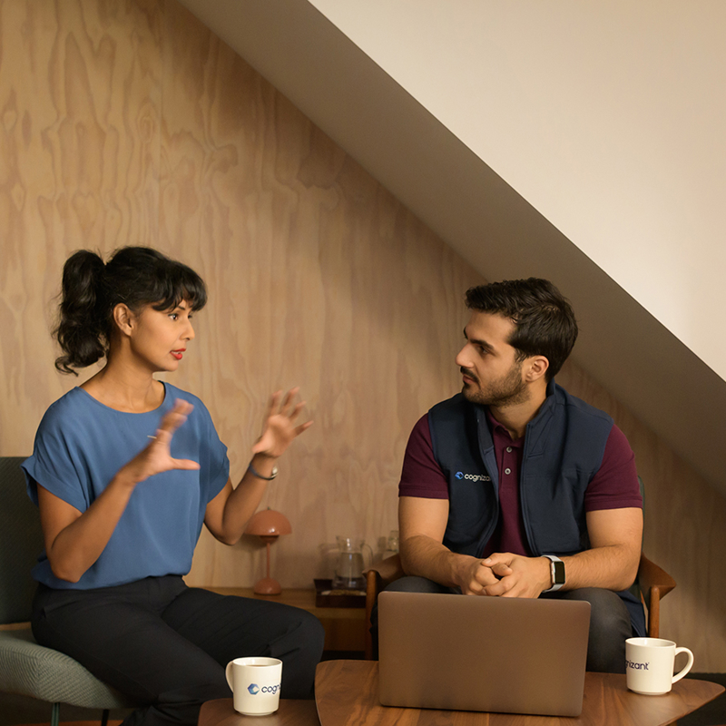 a person and person sitting on a chair with a laptop