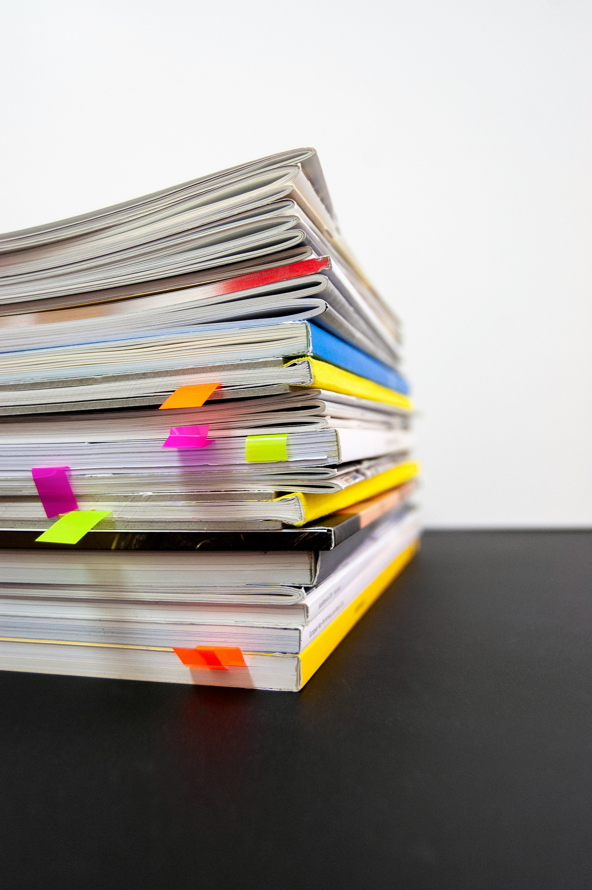 a stack of books with colorful paper clips