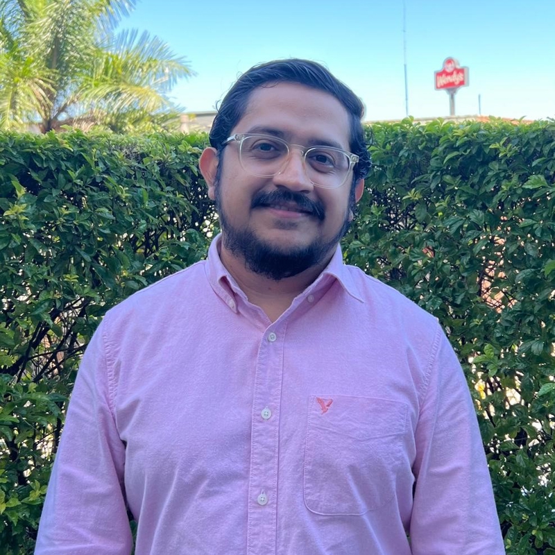 una persona con gafas y una camisa rosa
