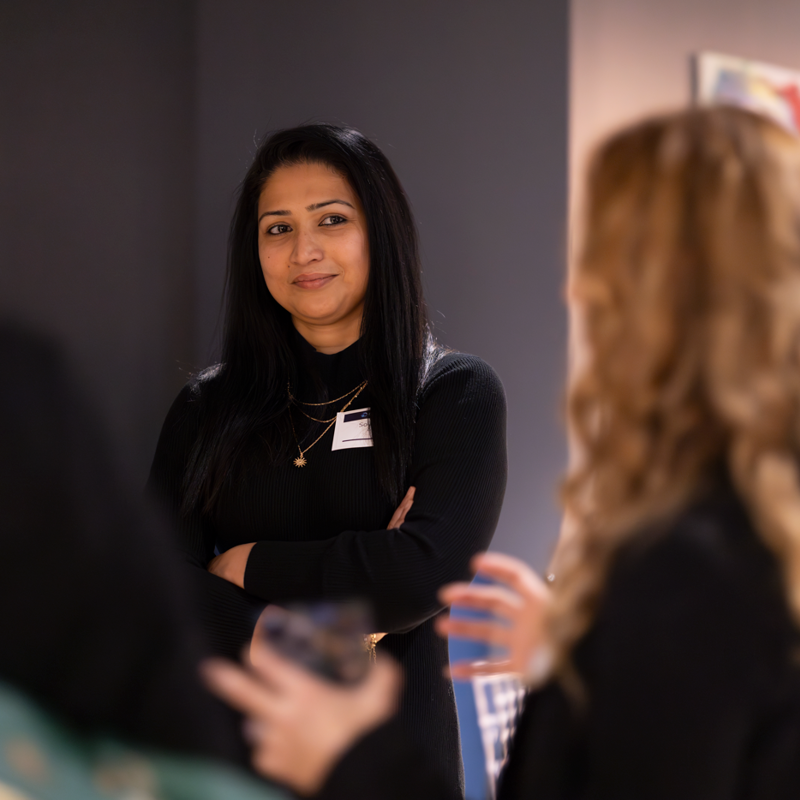 a person standing in front of a group of women