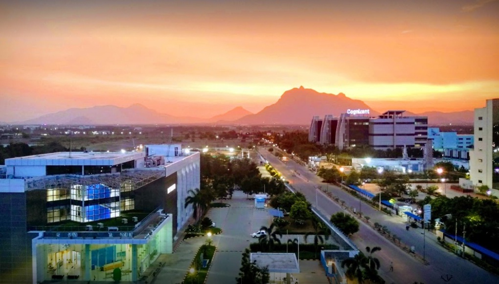a city with buildings and mountains in the background