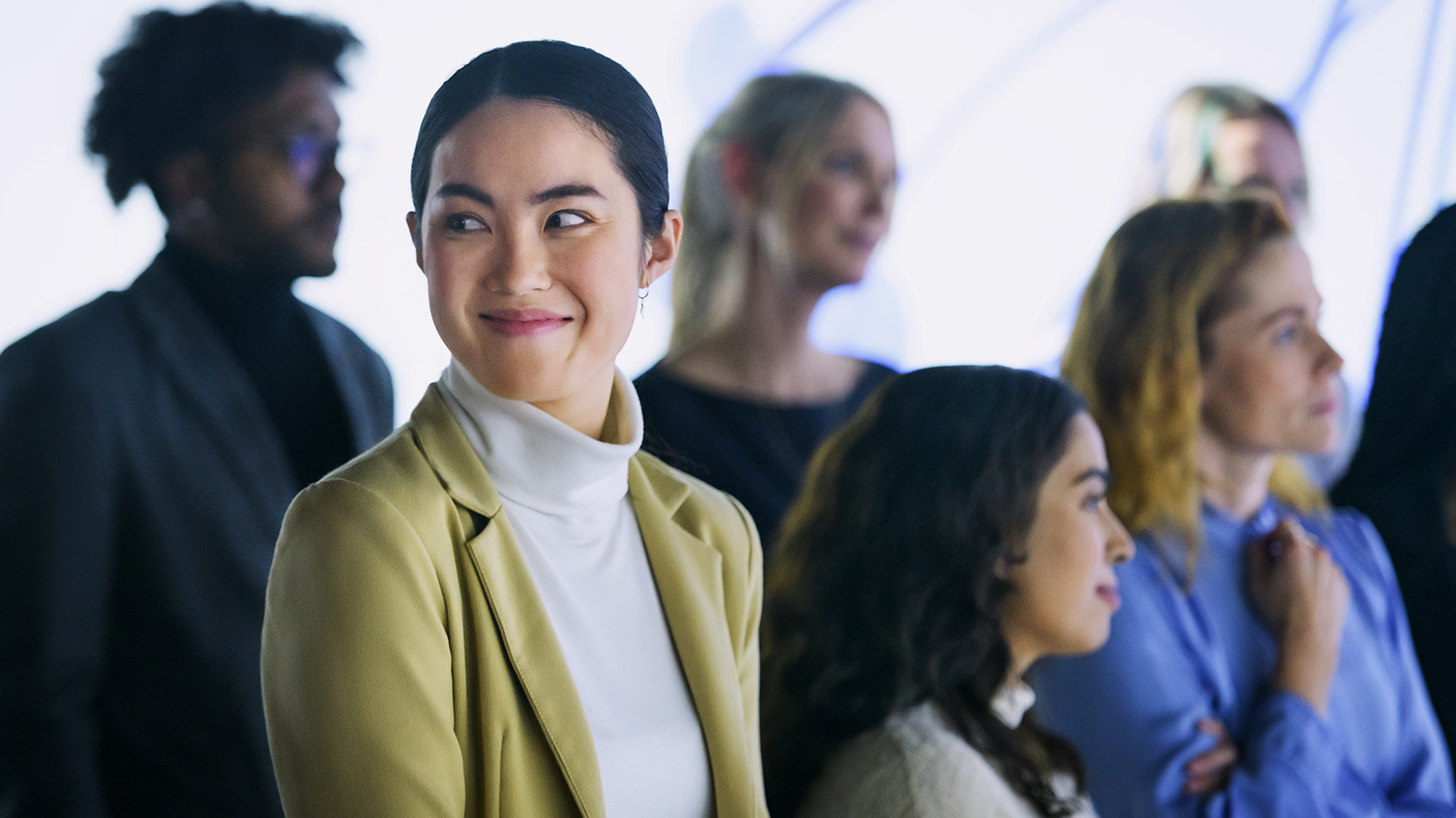 a person in a white turtleneck and a yellow jacket