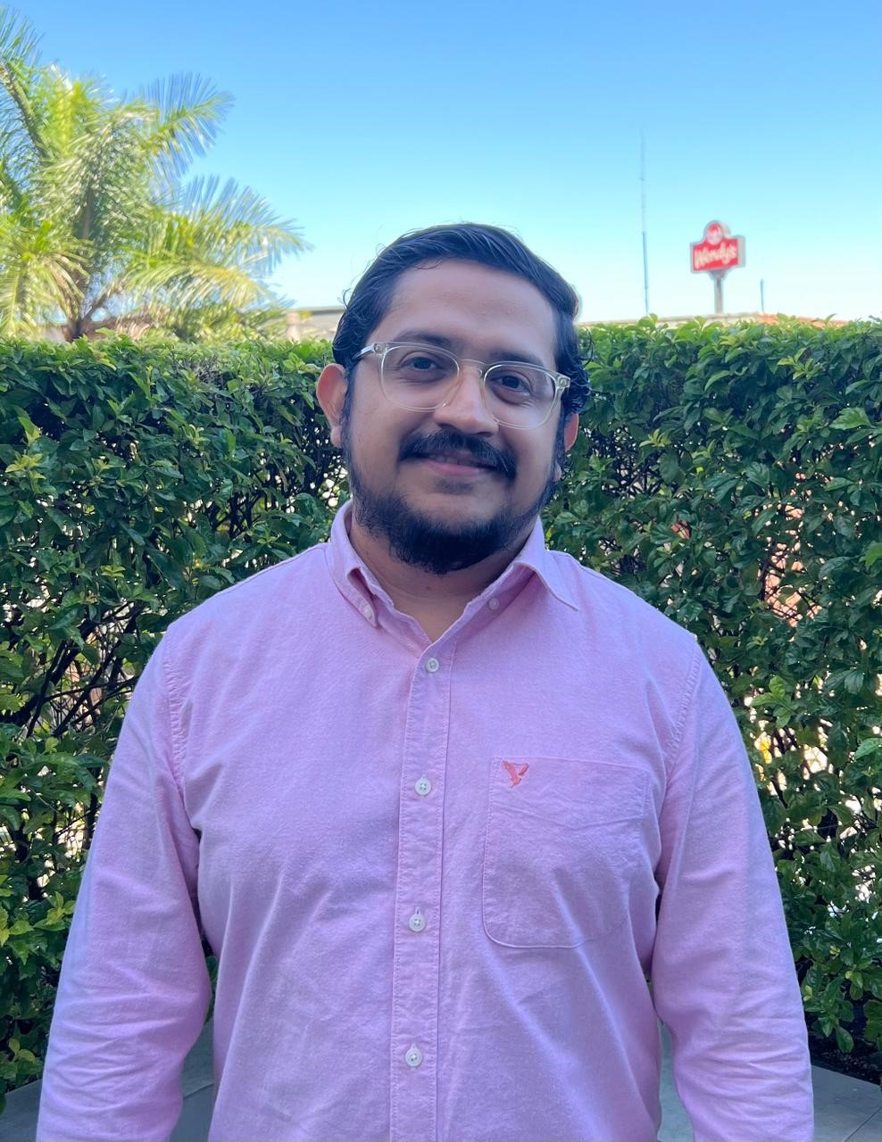 una persona con gafas y una camisa rosa