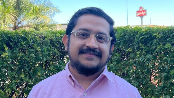 una persona con gafas y una camisa rosa