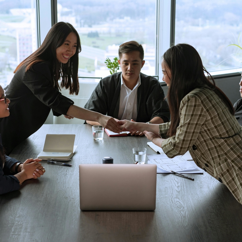 a group of people shaking hands around a table