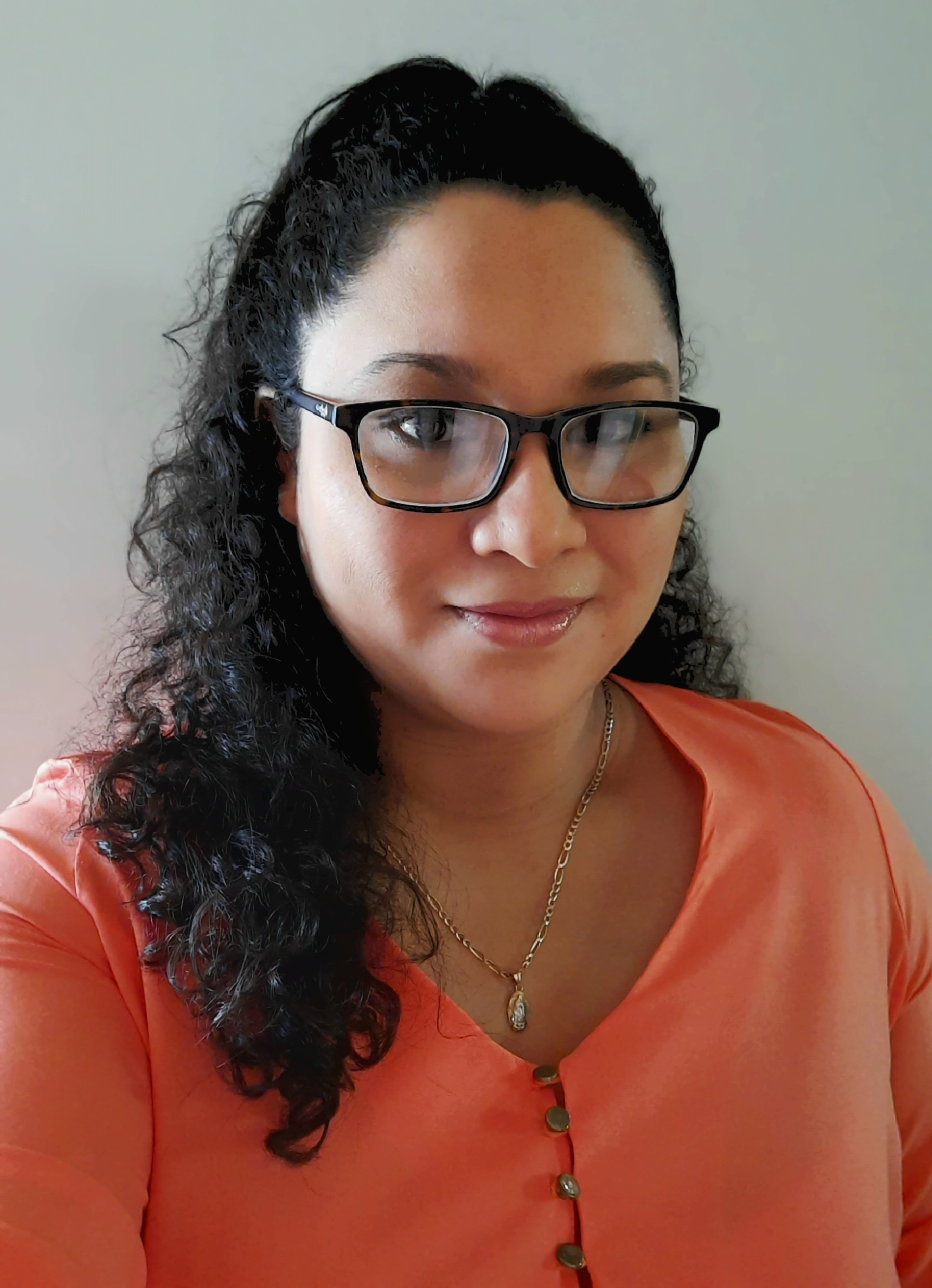 una persona con gafas y una camisa coral