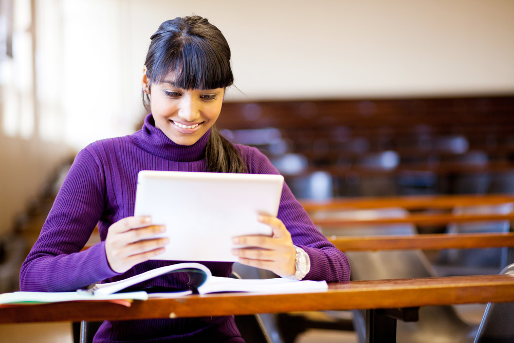 a person in a purple sweater looking at a tablet